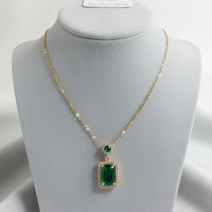 Emerald green pendant necklace displayed on white jewelry mannequin stand