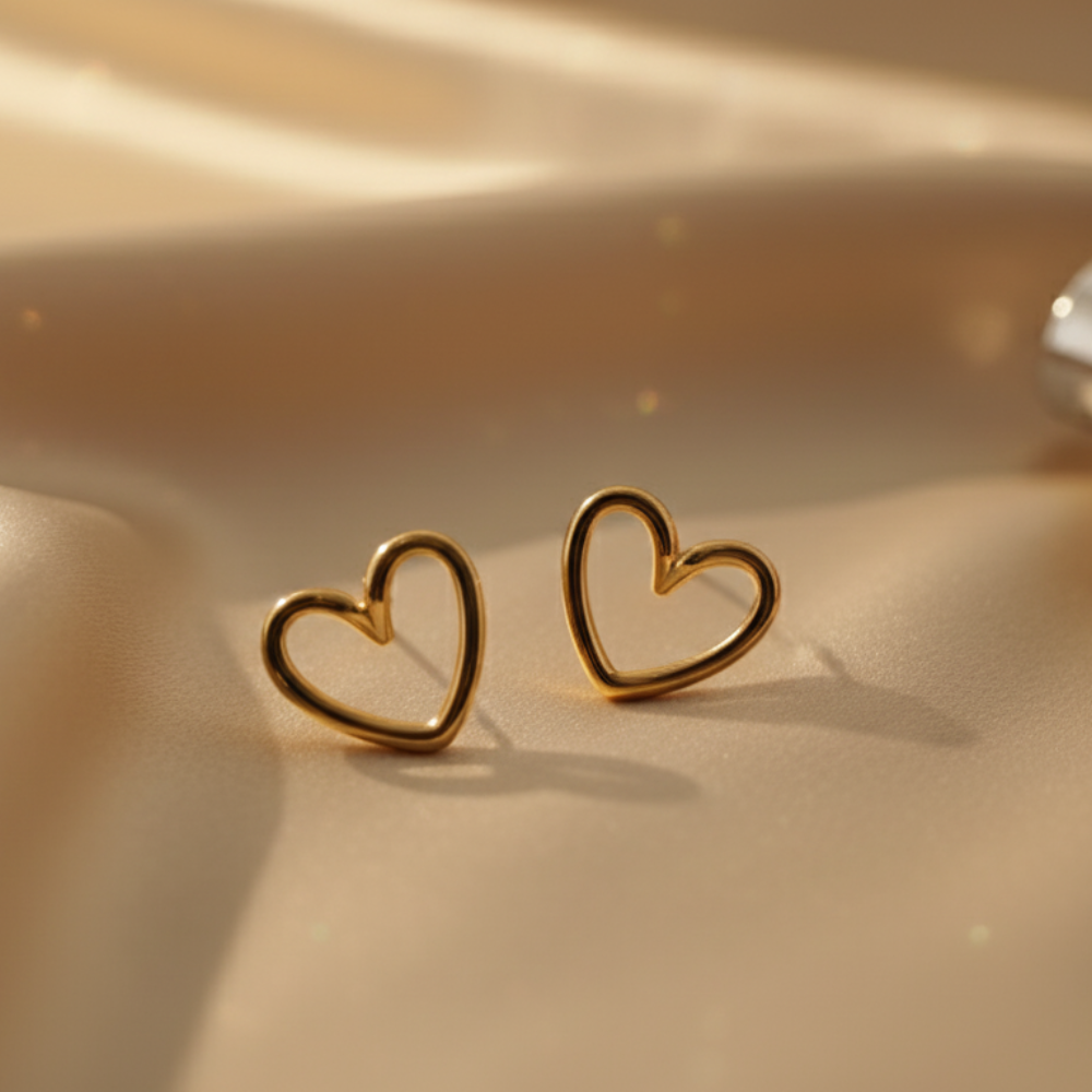 Aesthetic gold open heart earrings on golden satin surface