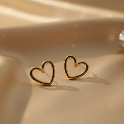 Aesthetic gold open heart earrings on golden satin surface