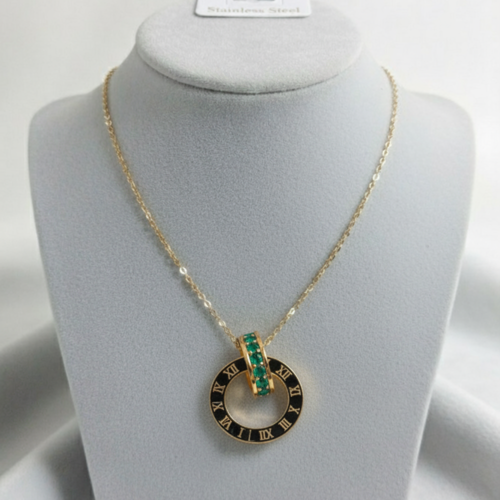 Gold Roman numeral pendant necklace with emerald stone displayed on jewelry mannequin