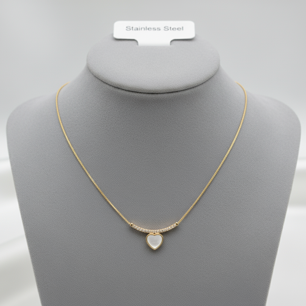 Gold necklace with white heart pendant displayed on jewelry mannequin