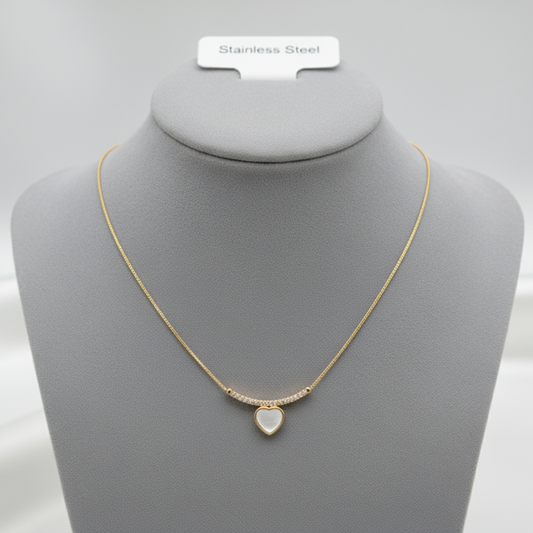 Gold necklace with white heart pendant displayed on jewelry mannequin