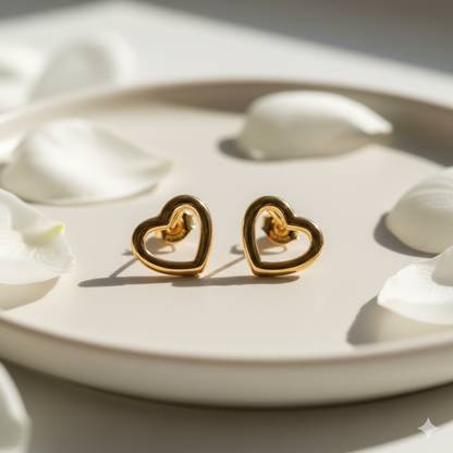 Gold open heart earrings on white satin cloth close-up