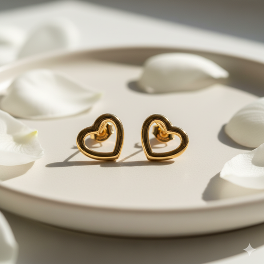 Gold open heart earrings on white satin cloth close-up